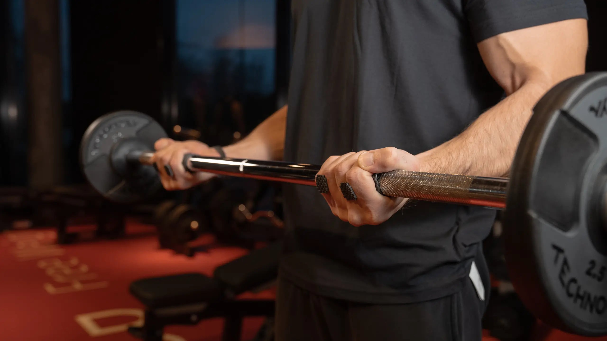 man is doing biceps curls with a barbell, he is using sillygrip lifting grip pads